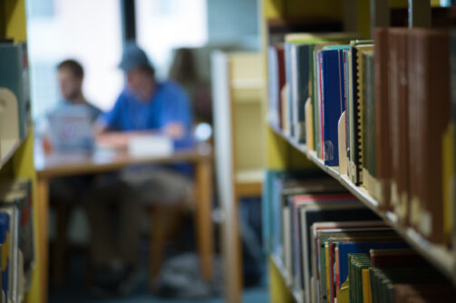 Book shelves with people studying in the distance