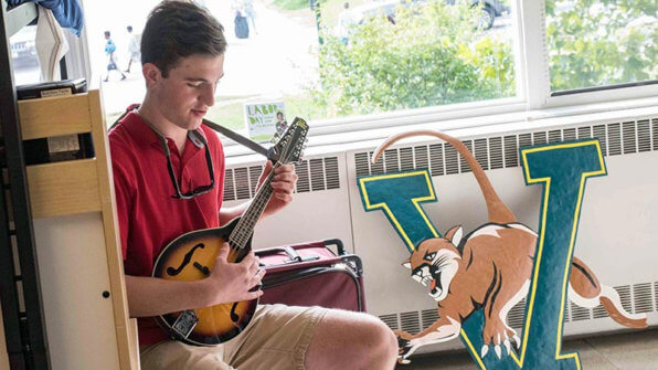 student plays a guitar