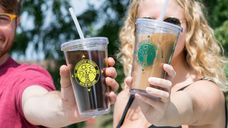 students holding wow tumblers