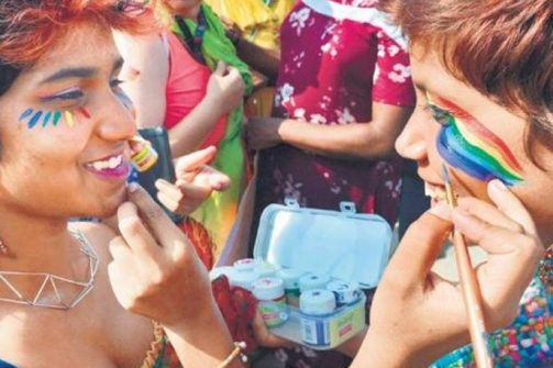 two people painting rainbows on each other's faces