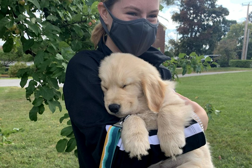 a student hugging a puppy