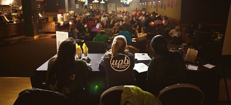 people wearing upb jackets facing a large audience