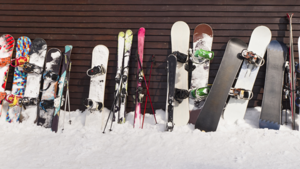 skiis and snowboards against a wall