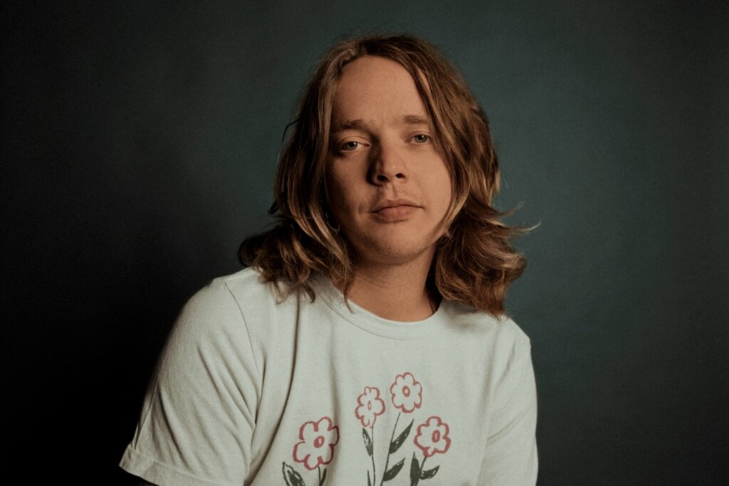 image of billy strings in front of a dark wall
