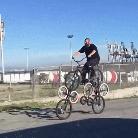 giphy of a person riding a bike that has 10 wheels
