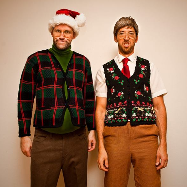 two people with obvious fake tan standing awkwardly next to eachother, both wearing holiday attire