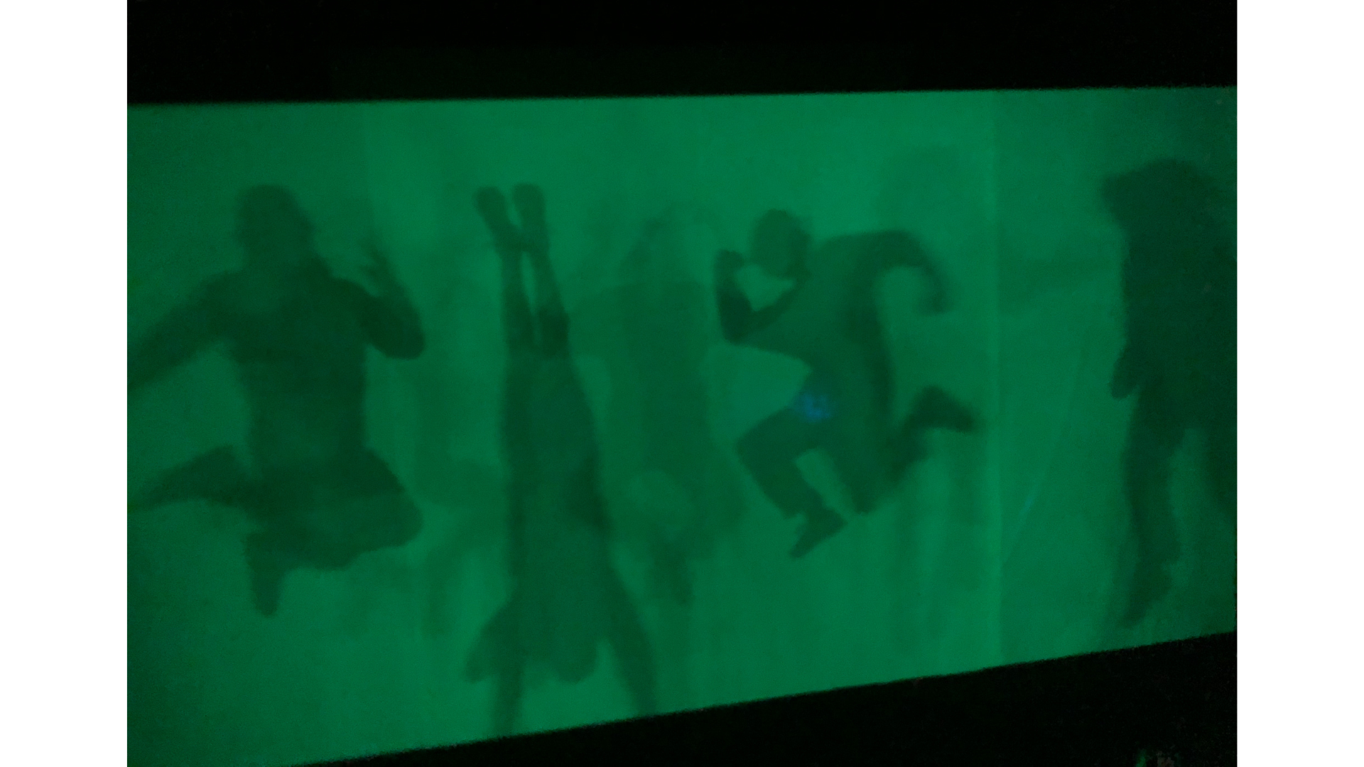 the silouette of four people against a green screen