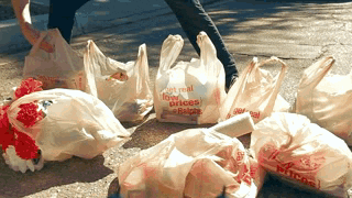 man grabs many grocery bags