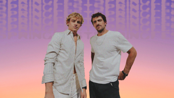 The SpringFest 2026 headliners, The Driver Era, pose in white shirts against an ombre sky that fades from purple to orange. Purple text that says "SpringFest" in a block font repeats subtly in the background.